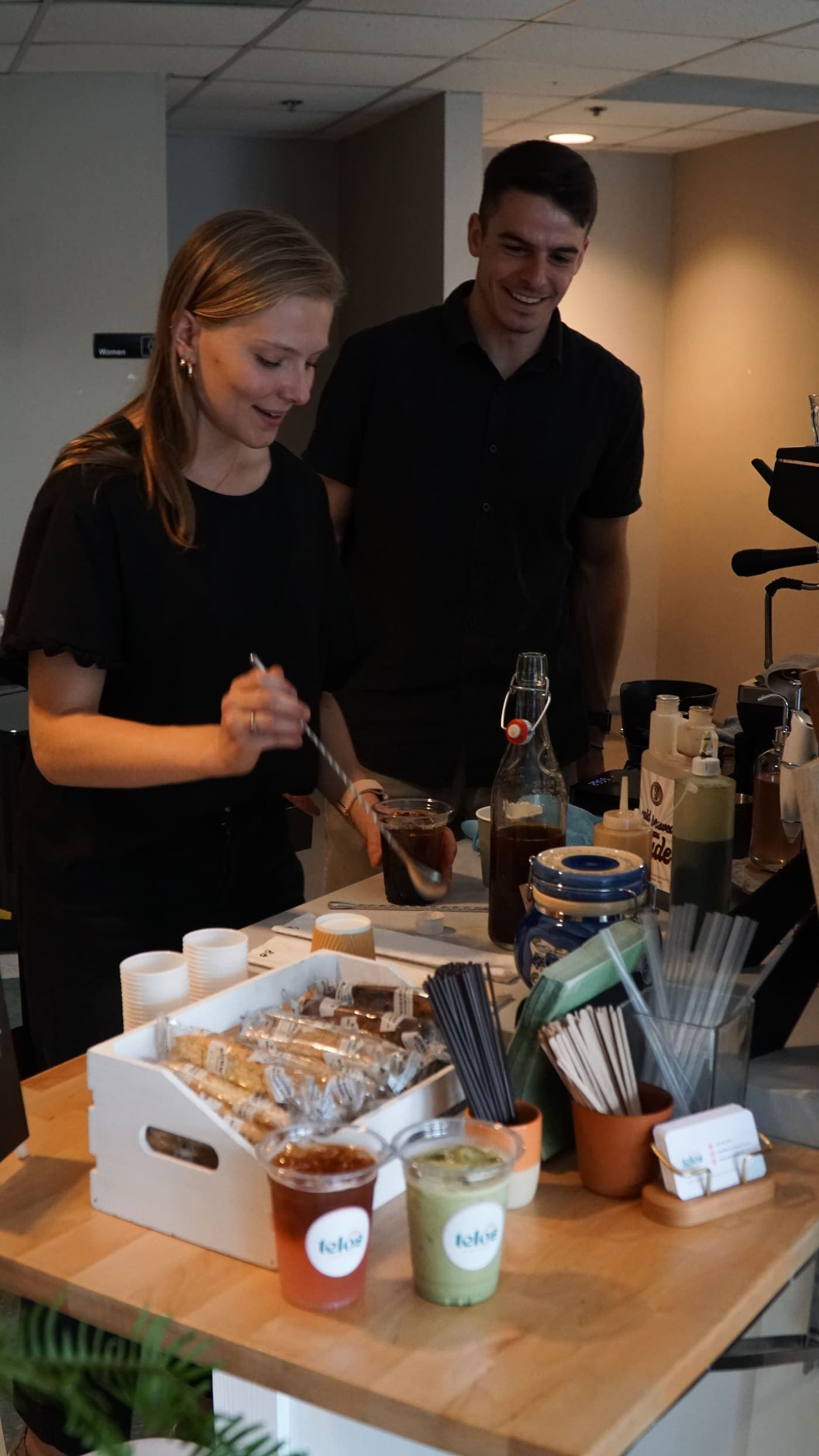 Two Telos Coffee baristas working side by side behind the cart