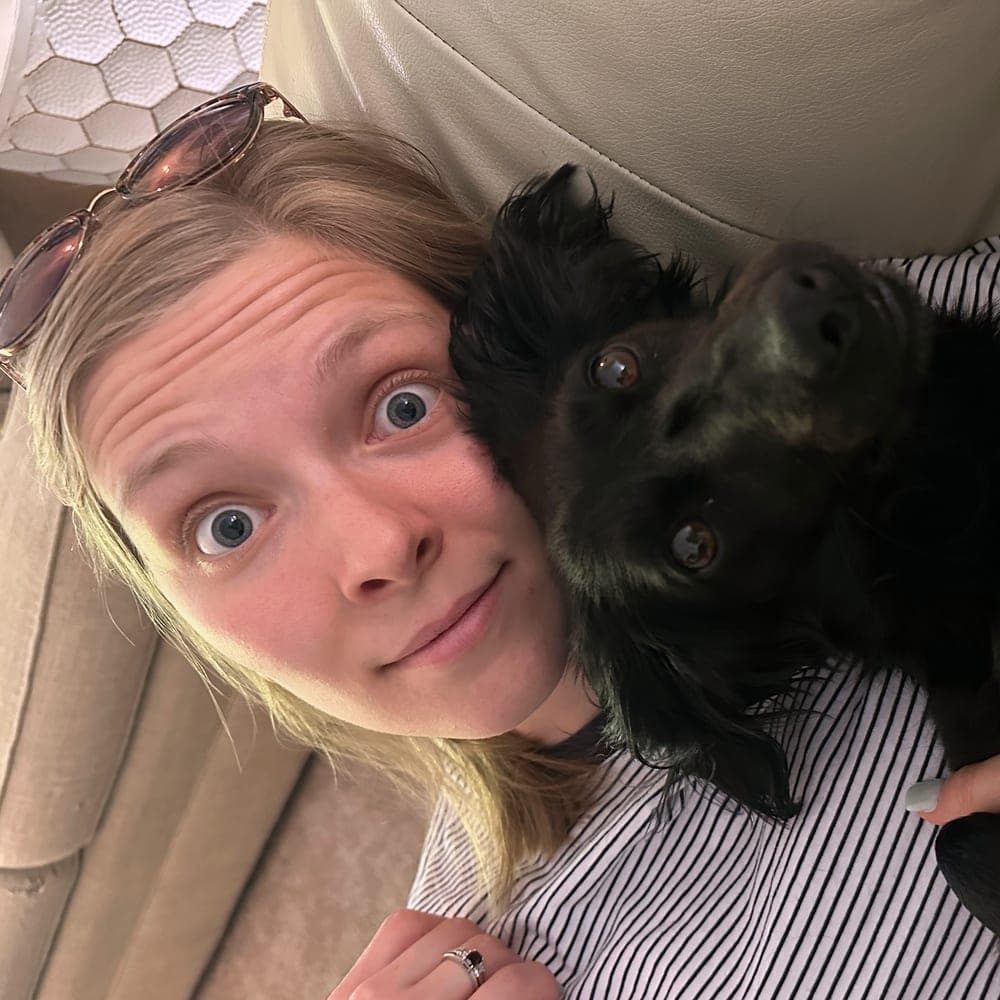 Melissa Kramer, co-founder of Telos Coffee, cheek to cheek with Dolly, the couple's black dog