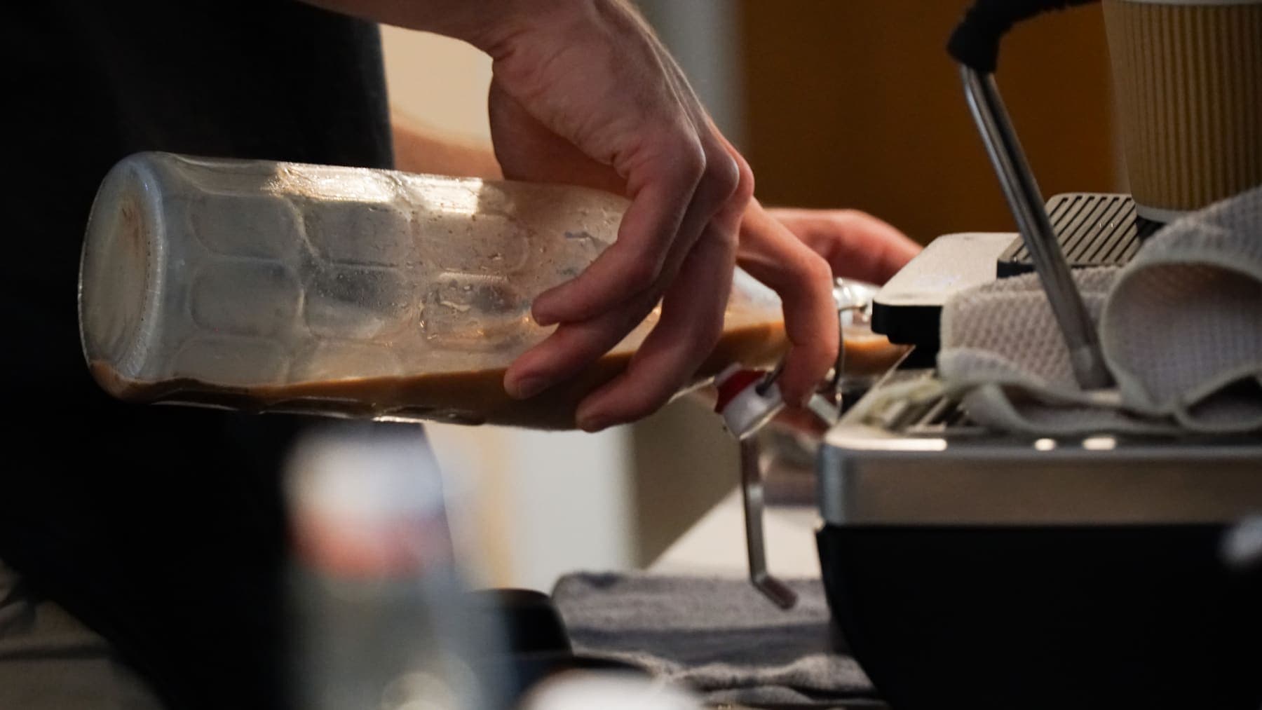 House syrup poured from a glass bottle while building a drink