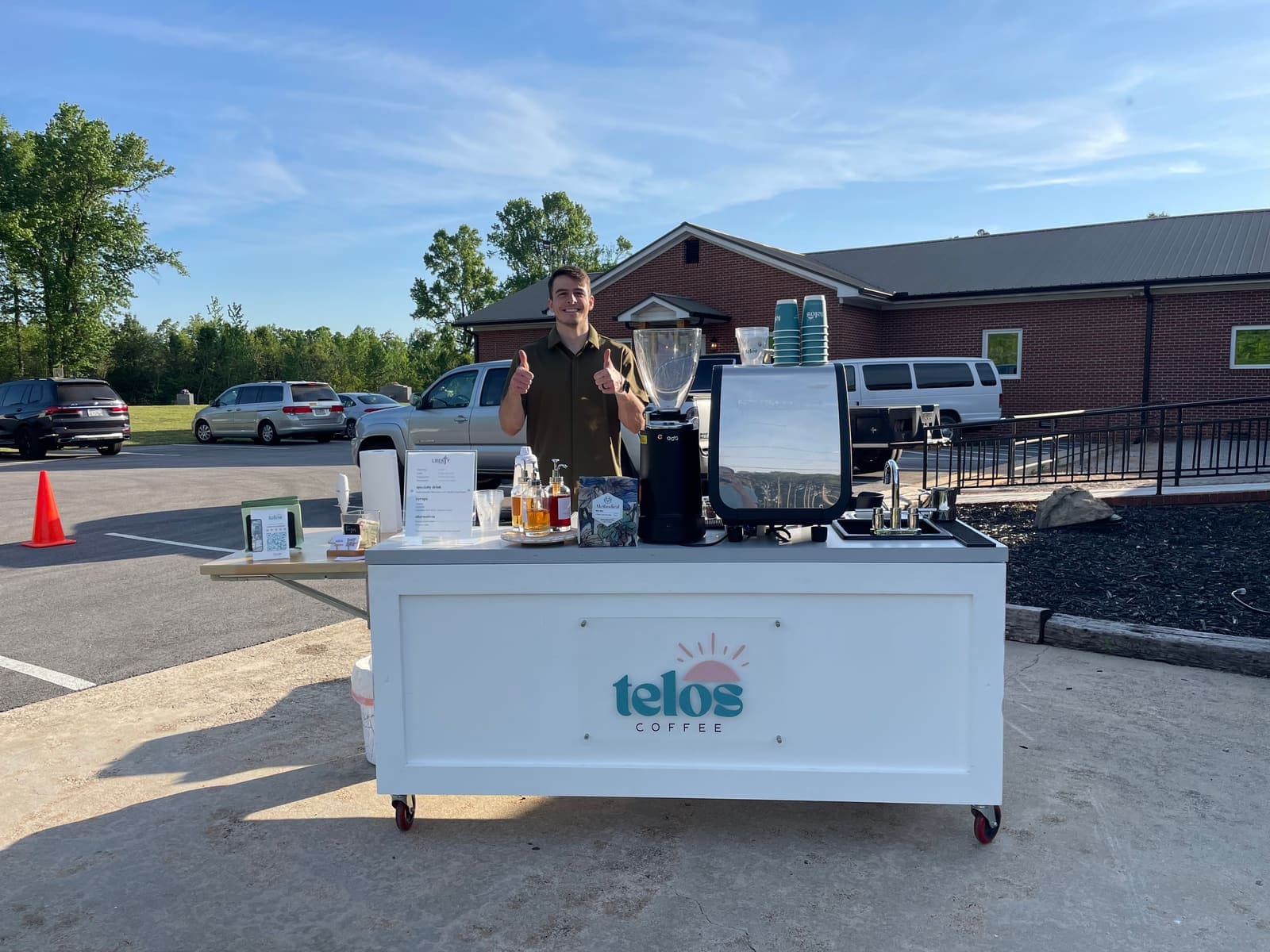 Tim set up outdoors beside the cart on a clear day, espresso machine ready before guests arrive